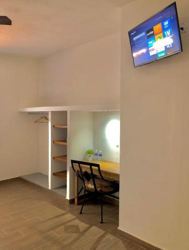 a room with a table and a tv on a wall at Quinta Los Caballos in Ajijic