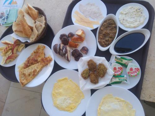 a table with plates of food on a tray at Palm Pyramid View Inn in Cairo