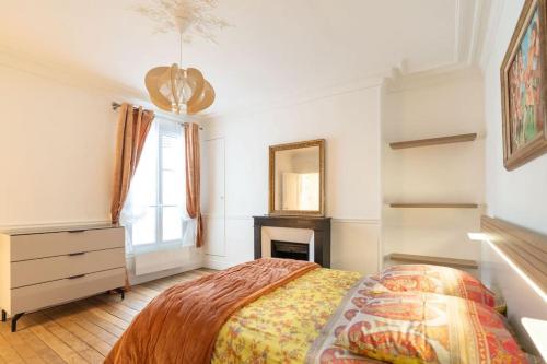 - une chambre avec un lit, une commode et une cheminée dans l'établissement 2 pièces à Saint Germain, à Paris
