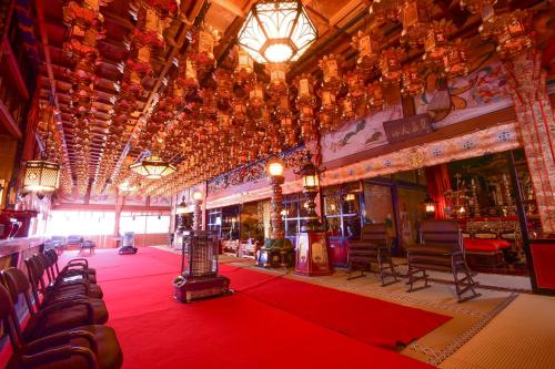 a large room with a red carpet and chairs at Koyasan Shukubo Saizenin in Koyasan