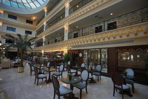 a restaurant with tables and chairs in a building at Habitat Hotel All Suites - Jeddah in Jeddah
