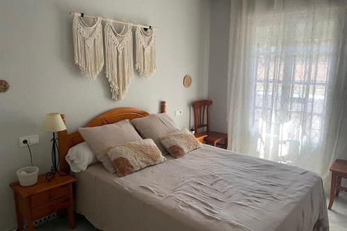 een slaapkamer met een bed met witte lakens en kussens bij Apartamento La Barrosa Beach in Novo Sancti Petri