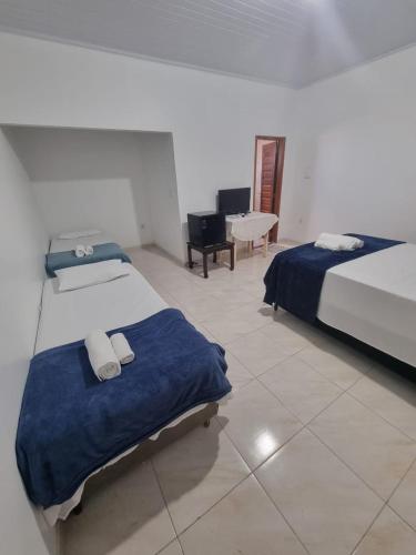 a hotel room with two beds and a piano at Pousada Talismã in Barreirinhas