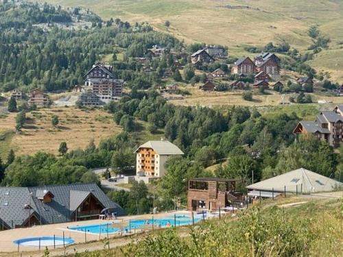 un petit village avec une piscine dans les montagnes dans l'établissement Appartement 8 personnes, au pied des pistes, à Saint-François-Longchamp
