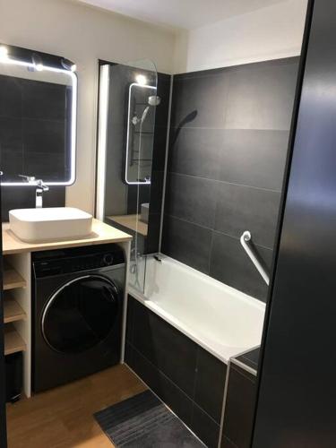 une salle de bain avec un lavabo et une machine à laver dans l'établissement Appartement 8 personnes, au pied des pistes, à Saint-François-Longchamp