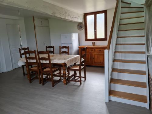 a kitchen with a table and chairs and a staircase at Gîte la Belle des Champs in Saint-Saire