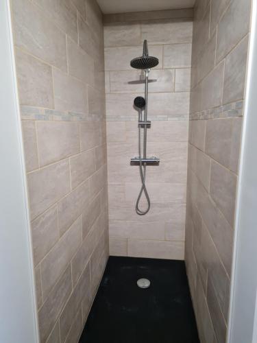 a bathroom with a shower with a black floor at Gîte la Belle des Champs in Saint-Saire