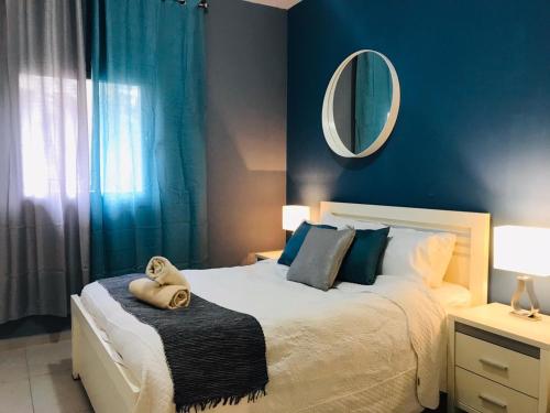 a bedroom with a large bed with a mirror on the wall at Harav Kuk Royal Suites - Alefimmoed in Jerusalem
