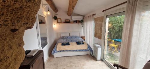 a bedroom with a bed and a large window at Appartement centre historique - climatisé avec extérieur au calme in Aix-en-Provence