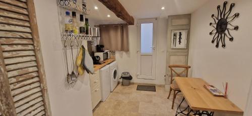 une petite cuisine avec une table et un réfrigérateur dans l'établissement Appartement centre historique - climatisé avec extérieur au calme, à Aix-en-Provence