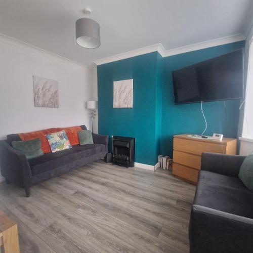 a living room with a couch and a tv at Belfast City house in Belfast