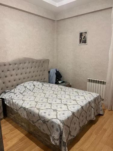 une chambre avec un lit avec une couette blanche dans l'établissement Qələbə Rezident, à Baku