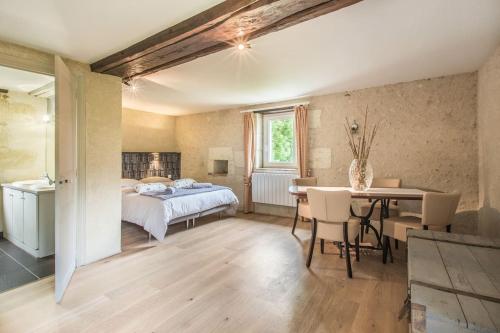 une chambre avec un lit, une table et des chaises dans l'établissement Domaine du Moulin de CHAREAU, à Reugny