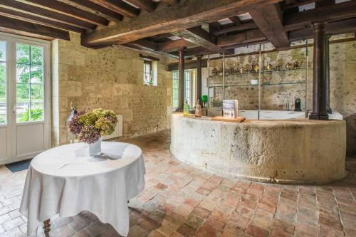 une pièce avec une table avec un vase de fleurs dessus dans l'établissement Domaine du Moulin de CHAREAU, à Reugny