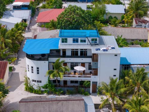 an aerial view of a white house with a blue roof at Hanifaru Beach Inn in Baa Atoll