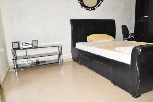 a bed with a black bed frame and a table at Magnifique villa avec piscine a Mbour in Mbour