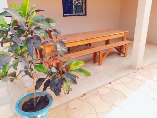 a wooden bench in a room with two potted plants at Magnifique villa avec piscine a Mbour in Mbour