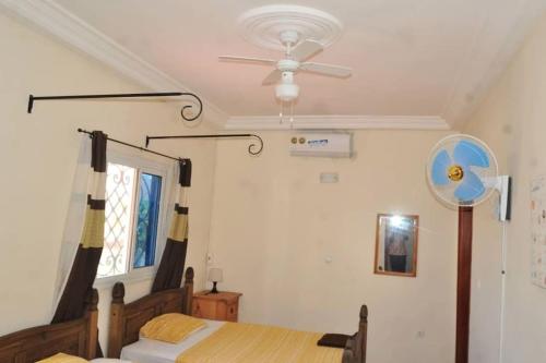 a bedroom with a bed and a ceiling fan at Magnifique villa avec piscine a Mbour in Mbour