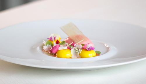 a plate of food with lemons and flowers on it at Boutique Hotel Residenz Winkler in Aschau im Chiemgau