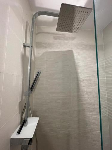 une douche avec une porte vitrée dans une salle de bain dans l'établissement Maison à Orgères, à Orgères