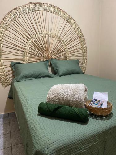 a bed with a large headboard with a basket on it at Hostel Wei in Boa Vista