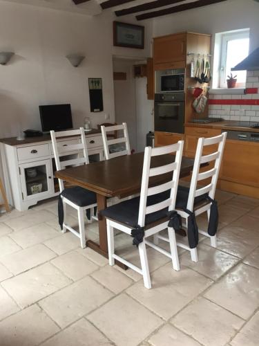 une cuisine avec une table en bois et quatre chaises dans l'établissement Gîte tout équipé au calme, à Saint-Amand-les-Eaux