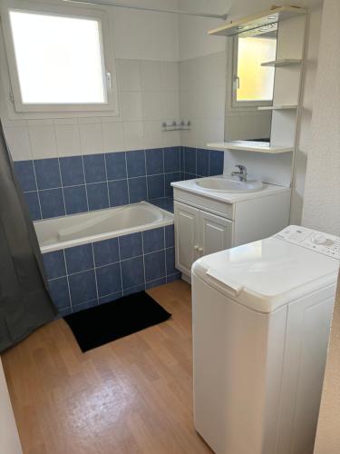 une salle de bain avec une baignoire, un lavabo et des toilettes dans l'établissement Appartement deux chambres paisible, à Vannes