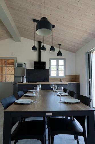 une table de salle à manger avec des verres à vin dessus dans l'établissement Maison neuve à 500m de la plage, La Menounière, à Saint-Pierre-dʼOléron