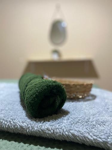a green towel sitting on top of a bed at Hostel Wei in Boa Vista