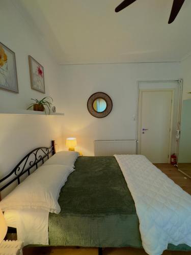 a bedroom with a large bed with a green blanket at Apartman Vasanija in Opatija