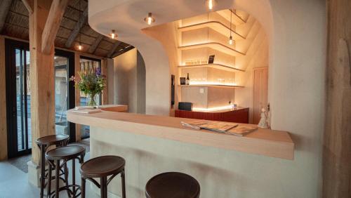 a bar in a restaurant with stools around it at B&B Het Nagtegaaltje in Collendoorn