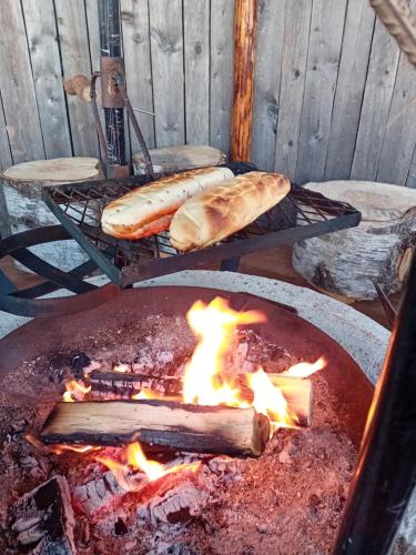two loaves of bread and a grill with fire at Experience accommadation Eco-Unela in Rovaniemi