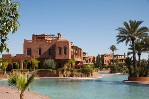 Una vista de un complejo turístico con palmeras y agua. en Villa Camélia des 3 Z, en Marrakech
