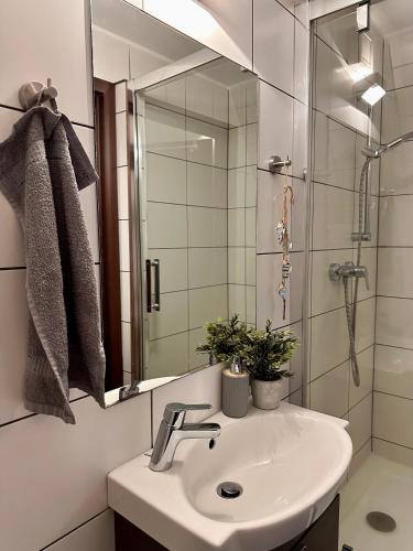 a bathroom with a sink and a shower and a mirror at Chata pri jazere in Banská Belá