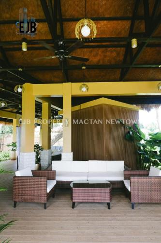a patio with white couches and chairs in a building at Mactan Newtown Beach Condo in Mactan