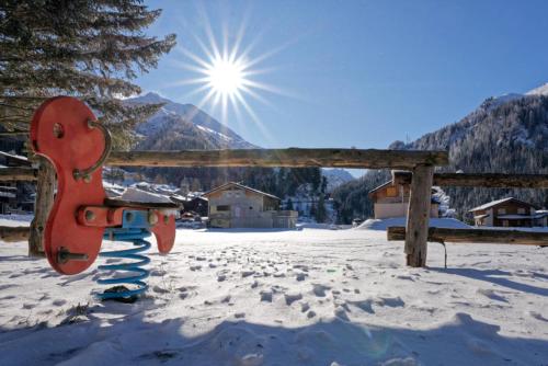 a playground in the snow with the sun in the background at Les Nis in Bourg-Saint-Pierre