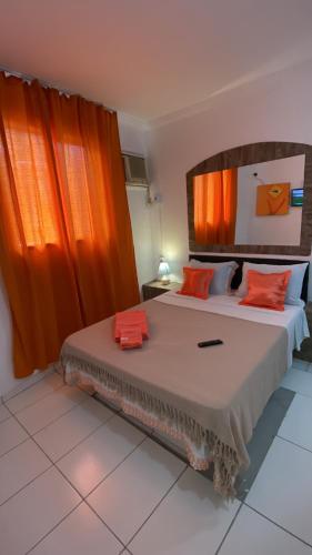 Schlafzimmer mit einem großen Bett und orangefarbenen Vorhängen in der Unterkunft SSA 33 Hotel in Salvador