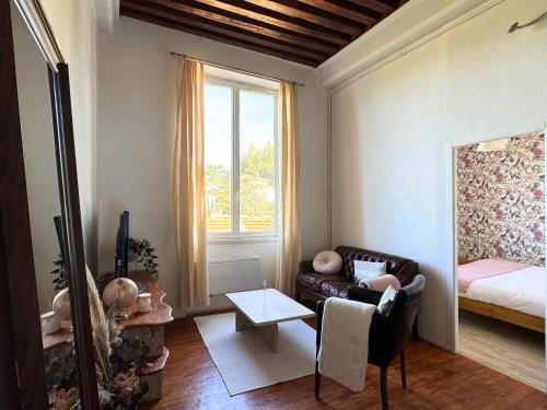 un salon avec un canapé et une fenêtre dans l'établissement Le Canut de Saint-Just - Lyon 9, à Lyon