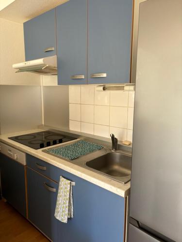 une petite cuisine avec un évier et un réfrigérateur dans l'établissement Appartement deux chambres paisible, à Vannes