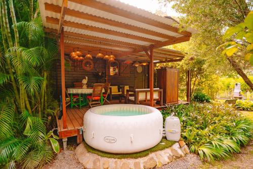 a hot tub sitting on a deck with a house at West Indies Cottage in Pointe-Noire