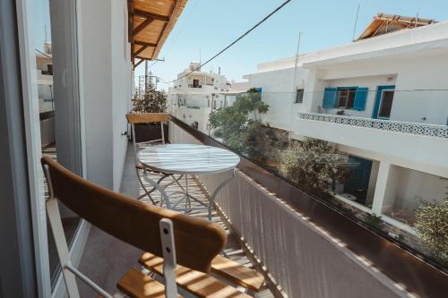 a balcony with a table and chairs on a building at Tesoro Elegant escapes- suites in Naxos Chora