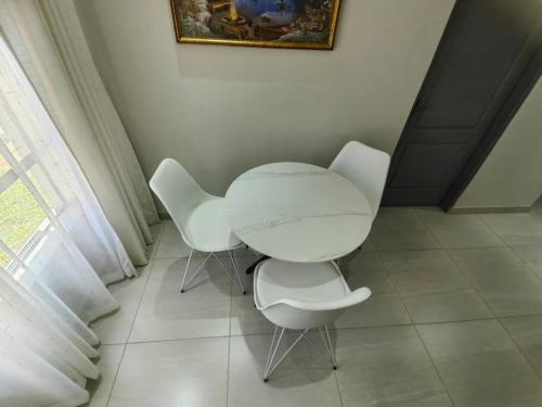 a white table and two white chairs in a room at Executive 2-bedroom Serenity apartment in Wendywood Sandton with its own entrance in Johannesburg