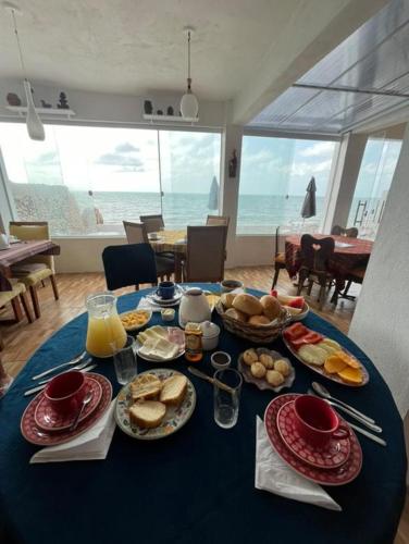a table with breakfast food on it with a view of the ocean at Pousada Di Ponta in Goiana