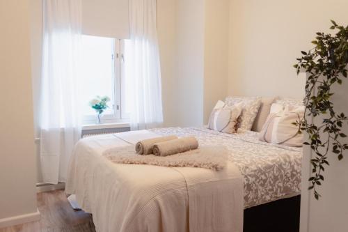 a bedroom with a bed with two towels on it at Modern Boho Charm in Kallio, Walk to City Center in Helsinki