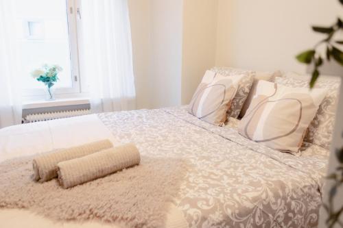 a white bed with pillows and a rug on it at Modern Boho Charm in Kallio, Walk to City Center in Helsinki