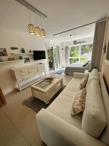 a living room with a white couch and a television at Green Park hermoso apartamento vista al lago in Punta del Este