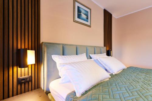 a bedroom with a bed with white pillows at Vila Tia in Karlovac