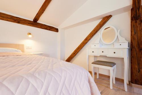 a bedroom with a bed and a desk with a mirror at Vila Tia in Karlovac