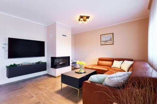 a living room with a couch and a flat screen tv at Vila Tia in Karlovac