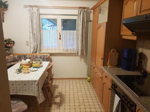 une petite cuisine avec une table et une fenêtre dans l'établissement Ferienwohnung Kahlersberg, à Schönau am Königssee